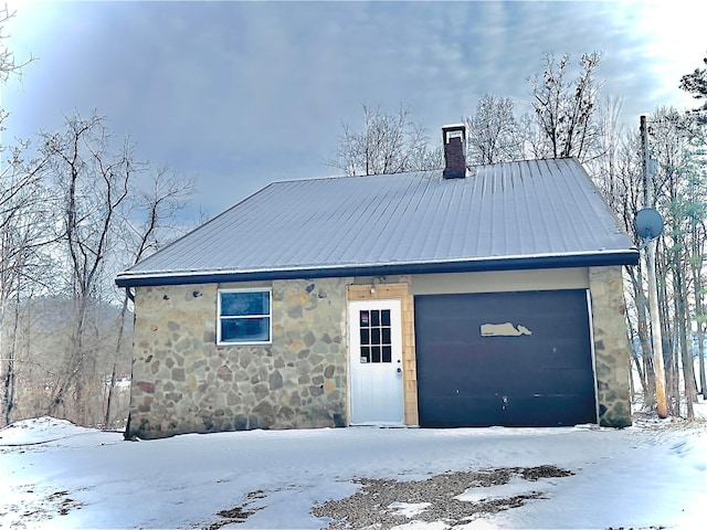 exterior space featuring stone siding, metal roof, and a chimney