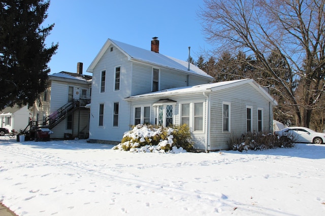 view of front of home with a chimney and stairway