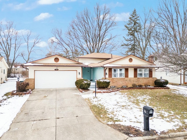 single story home with a garage, driveway, and brick siding