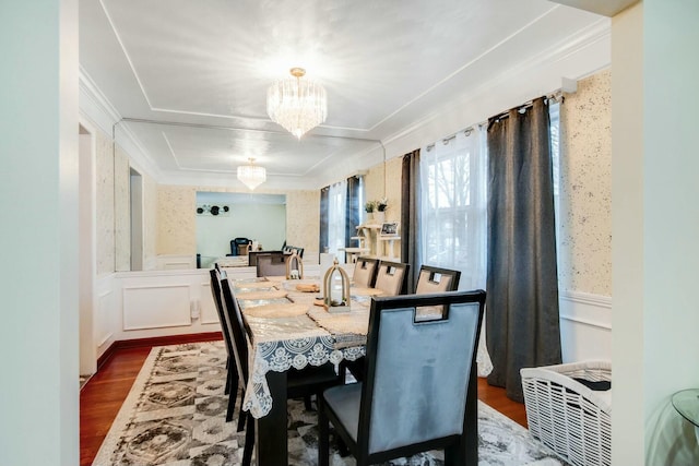 dining space with a chandelier, dark wood-type flooring, wainscoting, and a decorative wall