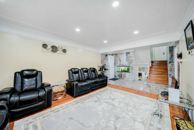 living room featuring recessed lighting, a fireplace, wood finished floors, stairway, and crown molding