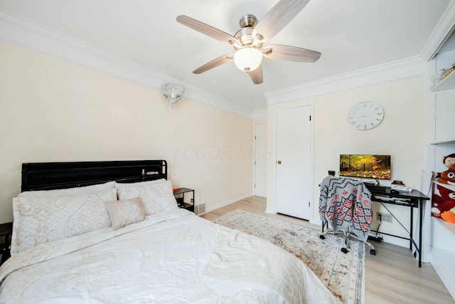 bedroom with light wood-style floors, a fireplace, crown molding, and a ceiling fan