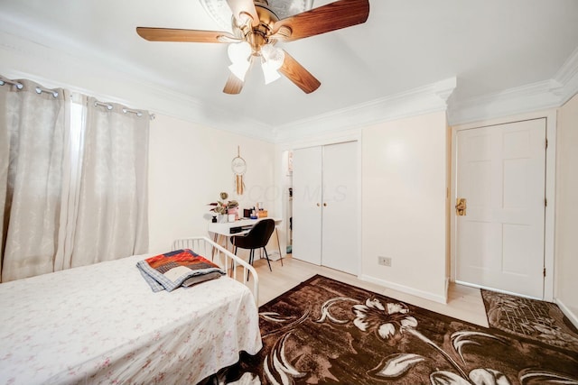 bedroom with a ceiling fan, a closet, crown molding, and light wood finished floors