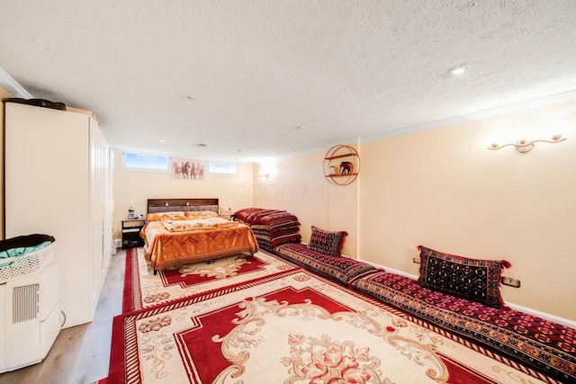 bedroom featuring a textured ceiling and light wood-style floors