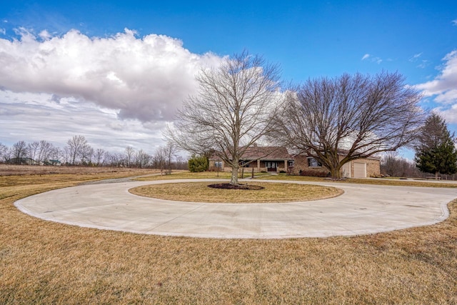 view of yard with curved driveway and an attached garage