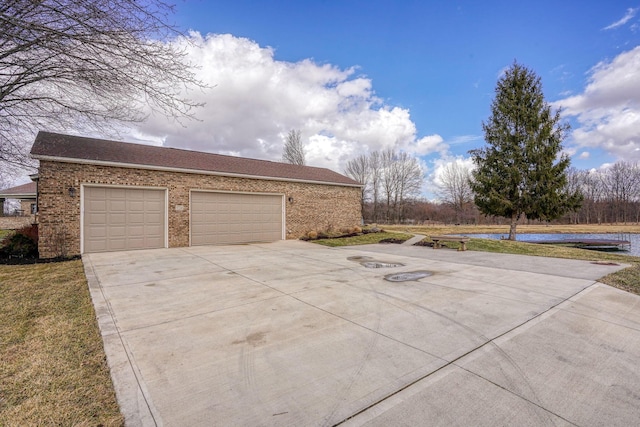 view of side of property with concrete driveway and brick siding