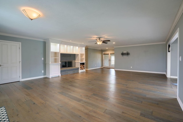 unfurnished living room with ornamental molding, dark wood finished floors, a fireplace, and baseboards