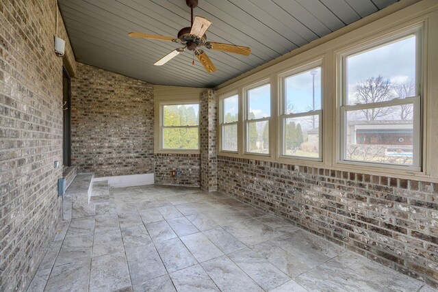 unfurnished sunroom featuring vaulted ceiling, ceiling fan, and wooden ceiling