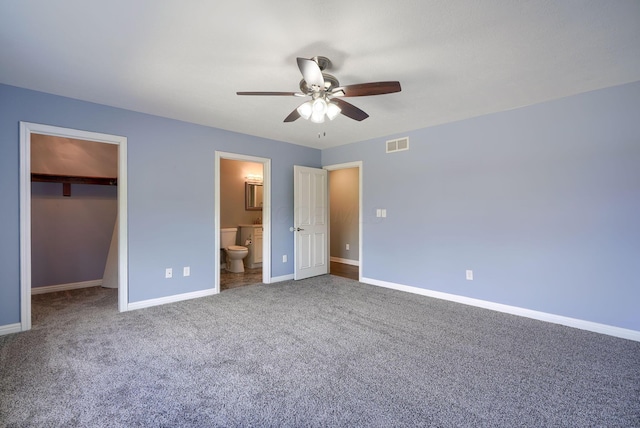 unfurnished bedroom with visible vents, baseboards, a spacious closet, a closet, and carpet