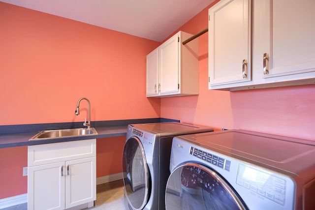 laundry area featuring independent washer and dryer, cabinet space, a sink, and baseboards