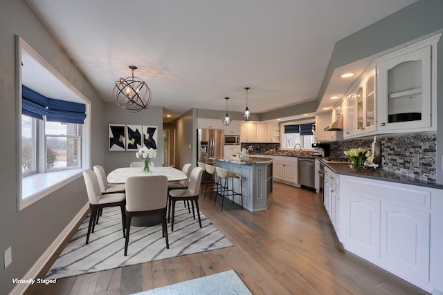 dining room featuring light wood-style floors, recessed lighting, baseboards, and an inviting chandelier