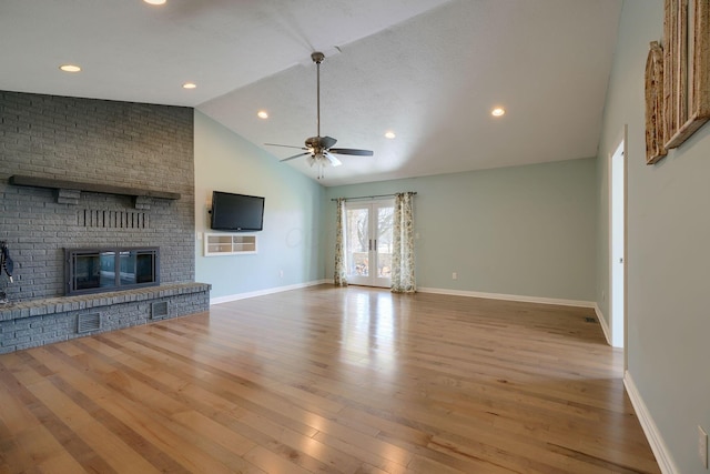 unfurnished living room with a ceiling fan, a brick fireplace, baseboards, and wood finished floors