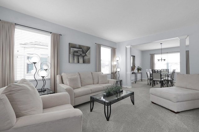 carpeted living area featuring ornate columns and plenty of natural light