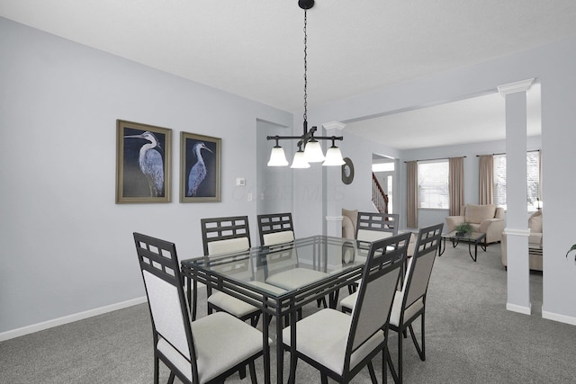 dining space with ornate columns, dark carpet, baseboards, and an inviting chandelier