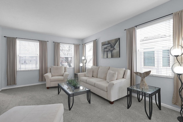 living area with a wealth of natural light, light carpet, and baseboards