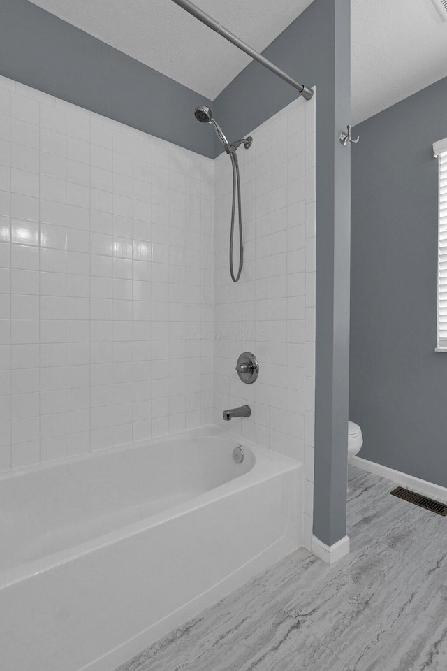 full bath with baseboards, visible vents, toilet, wood finished floors, and shower / bathing tub combination