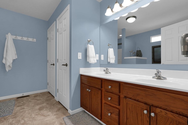 bathroom featuring tile patterned flooring, visible vents, a sink, and double vanity