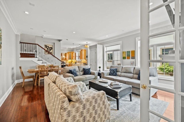 living room featuring a wealth of natural light, stairs, dark wood-style flooring, and crown molding