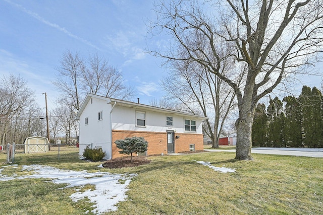 view of property exterior featuring an outbuilding, brick siding, stucco siding, a lawn, and fence