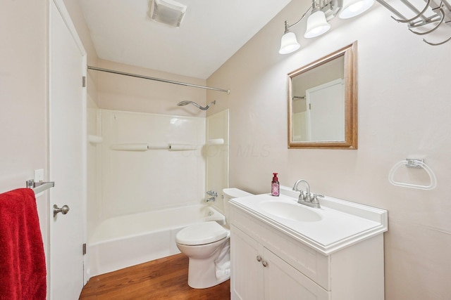 bathroom featuring toilet, wood finished floors, visible vents, vanity, and bathing tub / shower combination