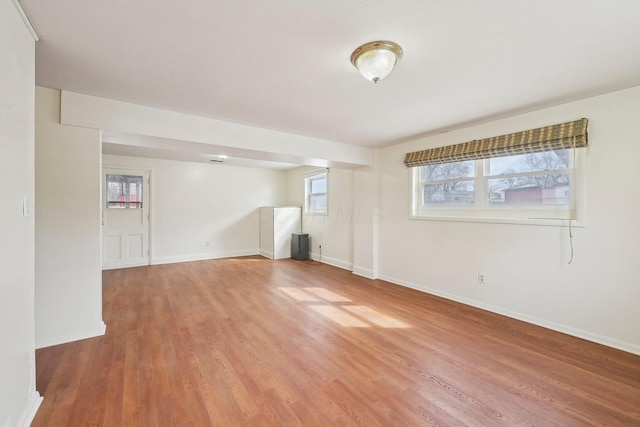 unfurnished room with light wood-style flooring and baseboards