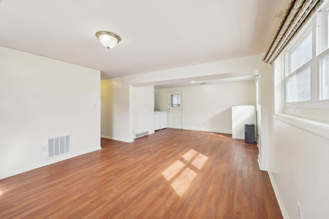 spare room featuring visible vents, light wood-style flooring, and baseboards