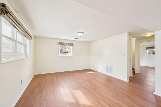 empty room with baseboards, visible vents, and light wood-style floors