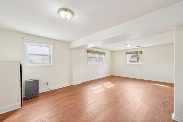 empty room with light wood-type flooring, a healthy amount of sunlight, and baseboards