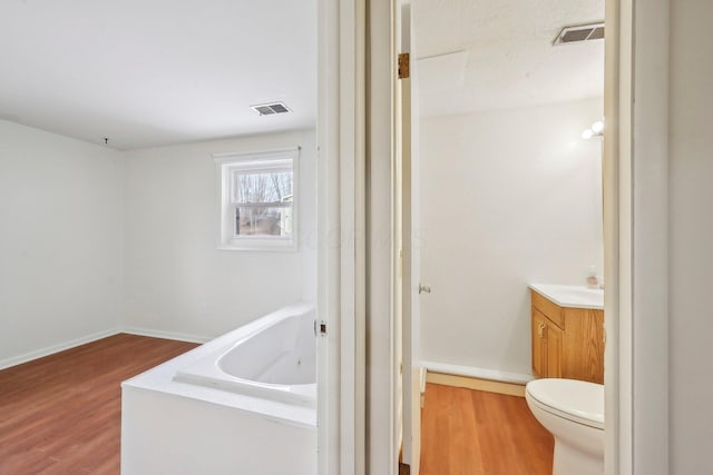 bathroom with visible vents, vanity, and wood finished floors