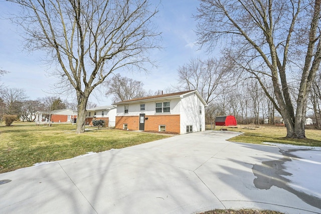 view of front of house featuring brick siding, a chimney, stucco siding, driveway, and a front lawn