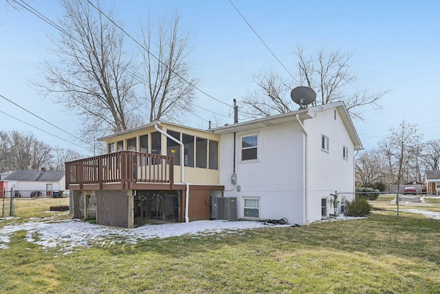 back of property featuring a sunroom, fence, a yard, central air condition unit, and stucco siding