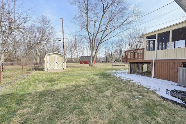 view of yard featuring an outbuilding, central air condition unit, a storage shed, a sunroom, and a fenced backyard