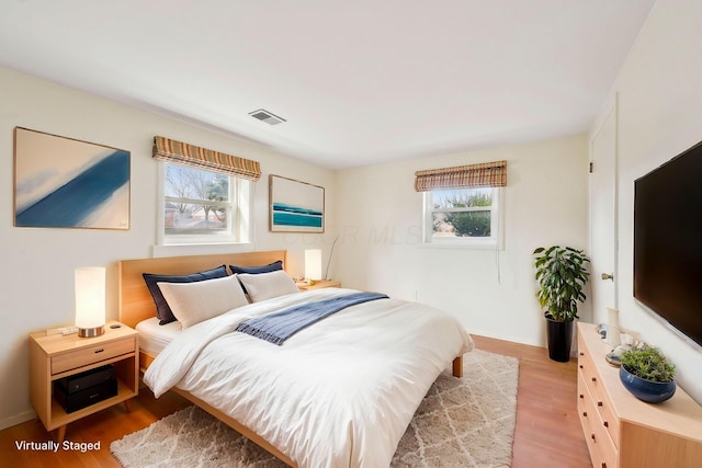 bedroom with wood finished floors and visible vents