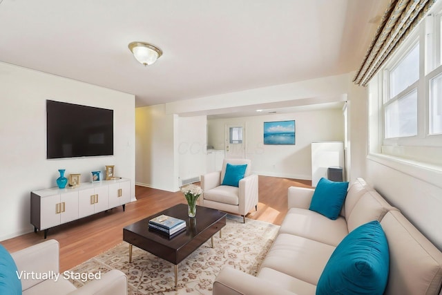 living area featuring baseboards and light wood-style floors