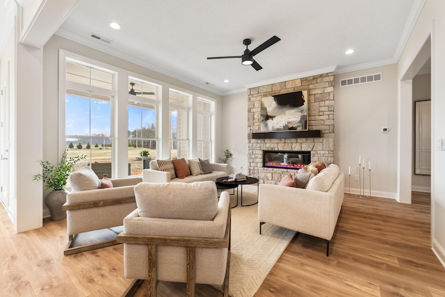 living room featuring ornamental molding, visible vents, and a fireplace