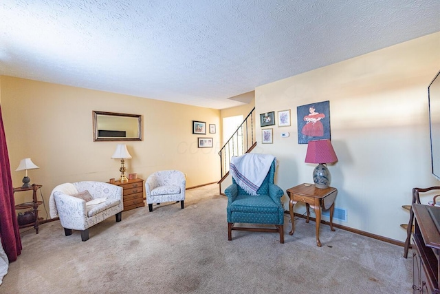 living area with a textured ceiling, stairway, carpet flooring, and baseboards