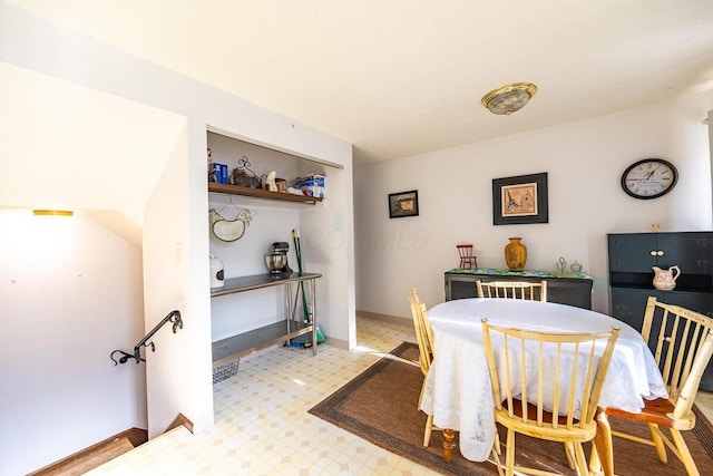 dining space with light floors and baseboards