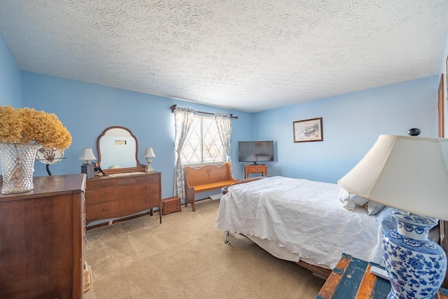 bedroom featuring light carpet and a textured ceiling