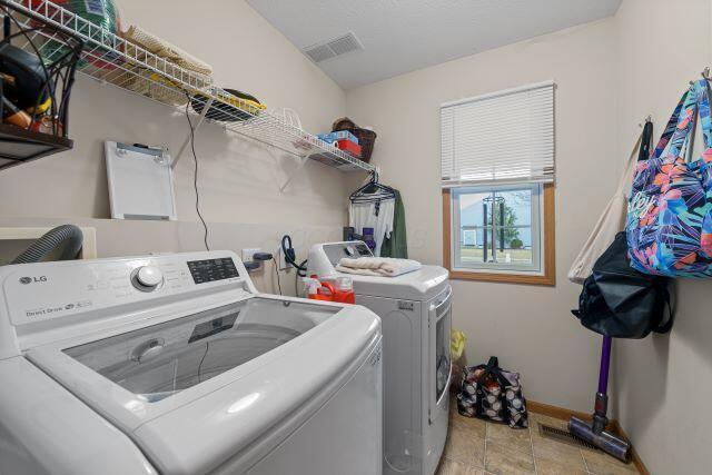 laundry room with laundry area, visible vents, baseboards, and separate washer and dryer