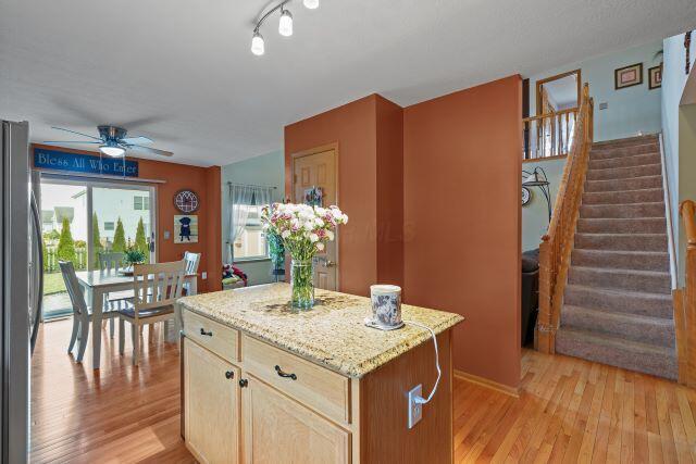 kitchen featuring light wood-style floors, a kitchen island, a ceiling fan, and freestanding refrigerator