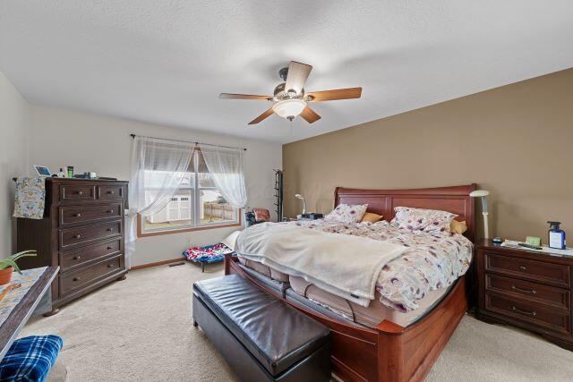 bedroom featuring a ceiling fan, light carpet, and baseboards