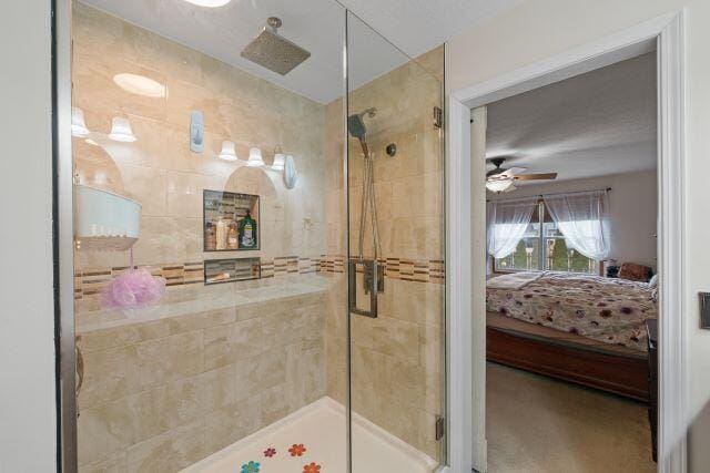 bathroom featuring a ceiling fan, a shower stall, and ensuite bath