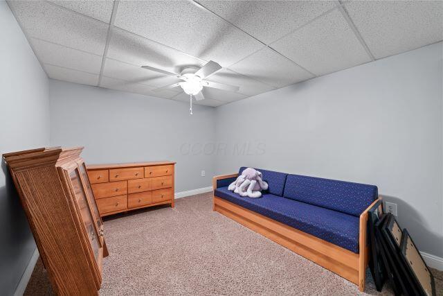 bedroom featuring ceiling fan, a drop ceiling, carpet, and baseboards