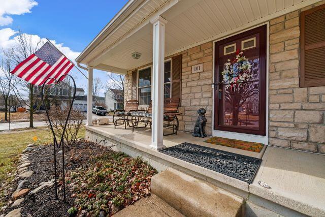 property entrance featuring stone siding and a porch