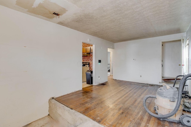 spare room with a textured ceiling and wood finished floors