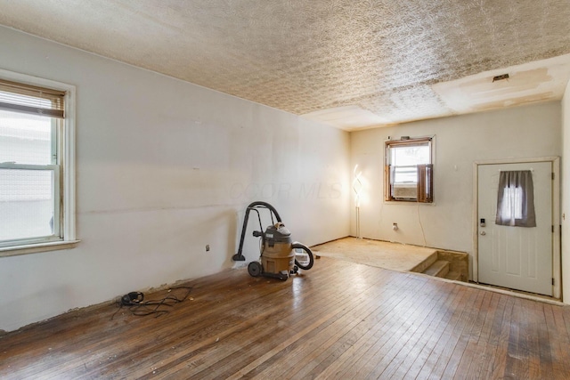 empty room with a textured ceiling and wood finished floors