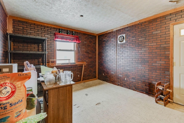 office featuring light floors, a textured ceiling, and brick wall