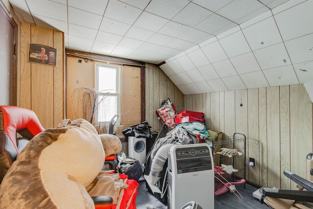 interior space featuring lofted ceiling, carpet, and wooden walls