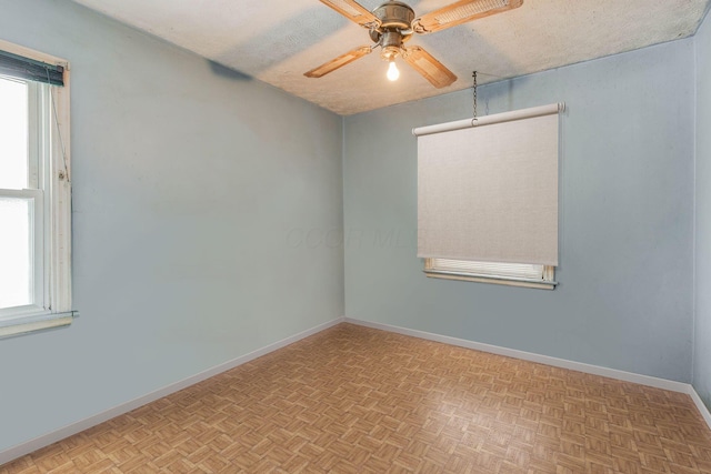 unfurnished room featuring a textured ceiling, baseboards, and a ceiling fan