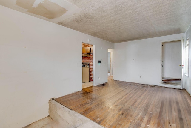 spare room with a textured ceiling and wood finished floors